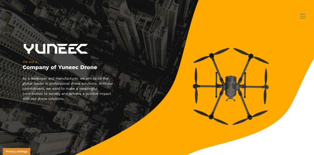 - RobotsInc.com Yuneec drone on an orange curved panel with a grayscale cityscape background, branding visible