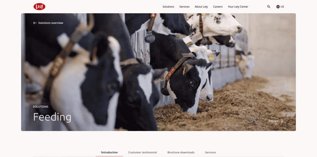 - RobotsInc.com Cattle feeding at a farm trough, black-and-white cows eating hay in a barn setting