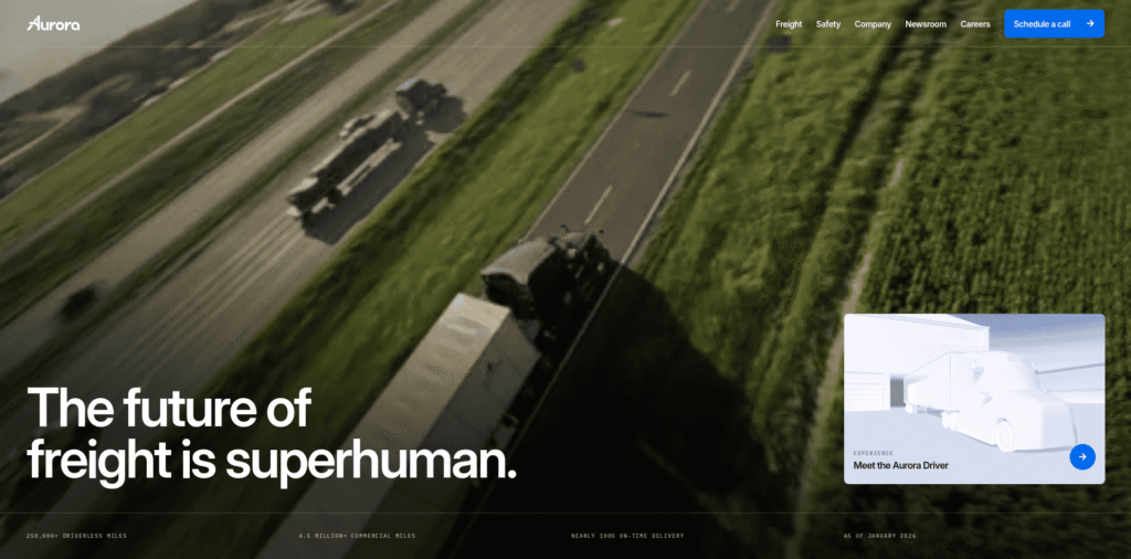 - RobotsInc.com Aerial view of trucks driving on a highway through green fields, overlaid with large white text: 'The future of freight is superhuman.' and a white 3D truck card in the bottom-right corner.