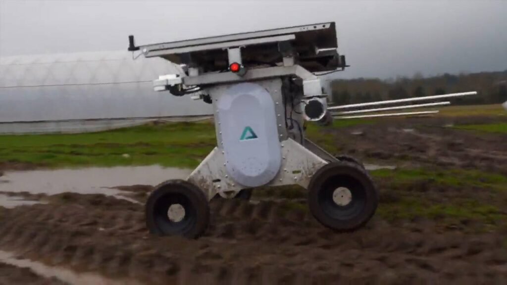 - RobotsInc.com Autonomous four-wheel robotic rover with a camera on top navigating a muddy field, logo on its side and a sun-facing panel above.