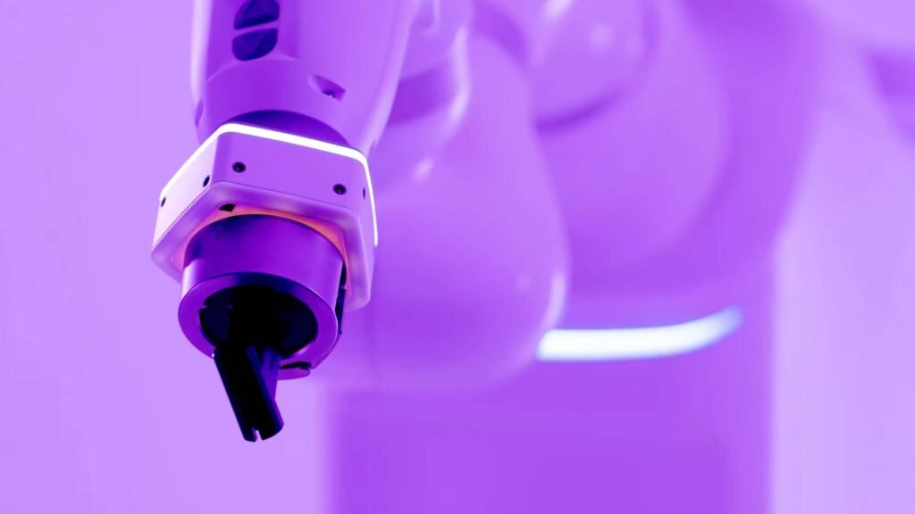 - RobotsInc.com Close-up of a robotic gripper in a purple-lit lab, highlighting automated manufacturing.