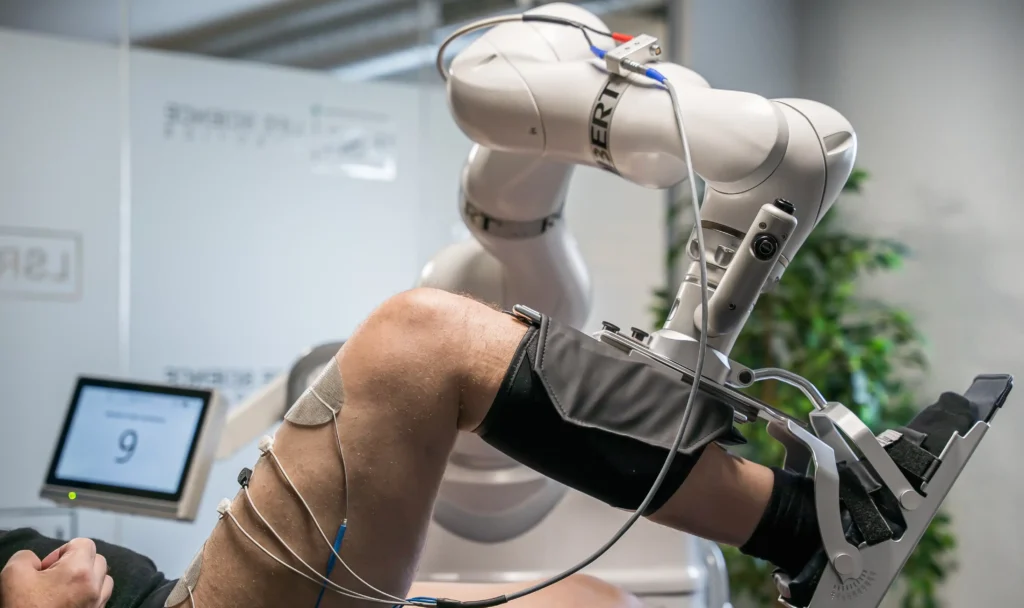 - RobotsInc.com Robotic arm attached to a patient’s arm during a medical procedure in a clinical setting in the operating room.