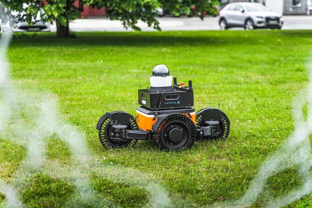 - RobotsInc.com Autonomous lawn-mowing robot operating on a grassy lawn inside a circular boundary wire.