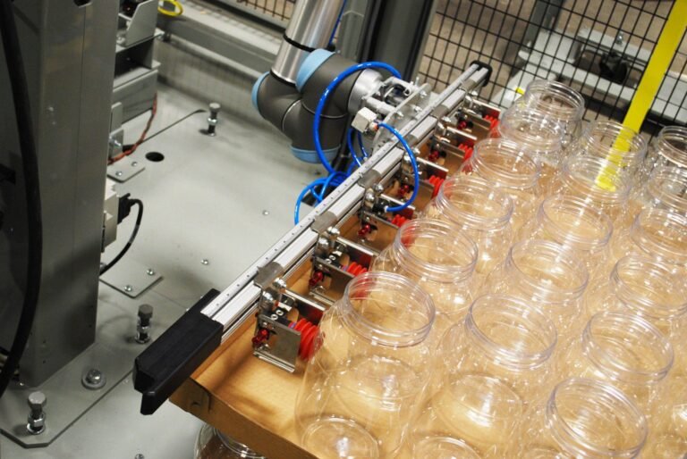 07 PresPic Robotic Fenceless Tray Bottle Loader Placing Containers Close Up scaled min 768x514