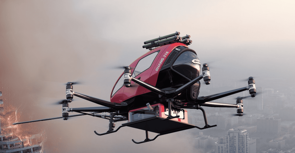 - RobotsInc.com Red multi-rotor drone in flight above a burning city, with smoke rising on the left.