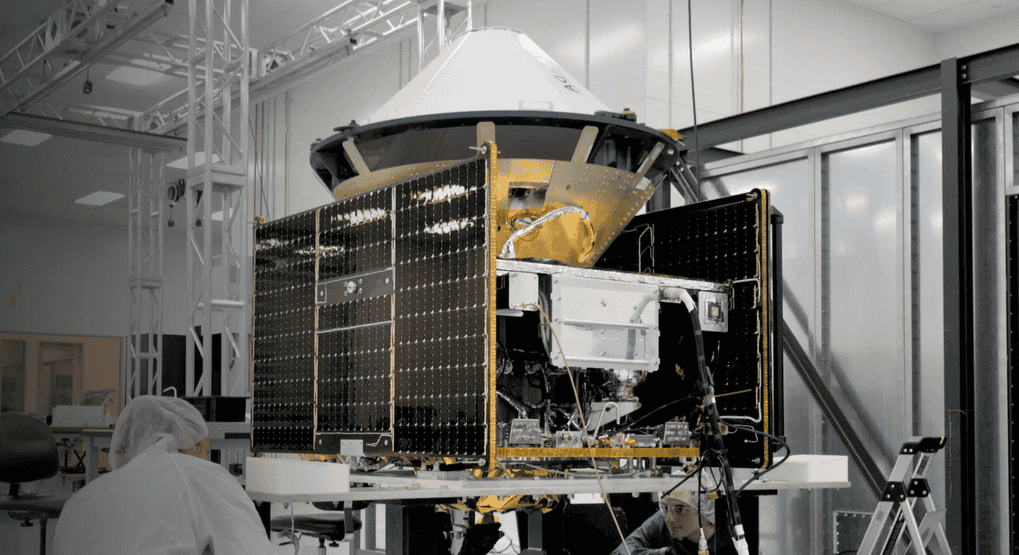 - RobotsInc.com Satellite payload under assembly in a cleanroom, engineers in protective suits working nearby