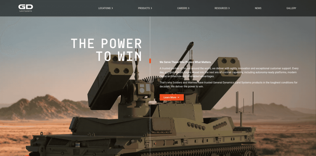 » RobotsInc.com Armored tank in a desert setting with bold white text 'THE POWER TO WIN' overlaid and an orange 'Learn More' button on the right side.